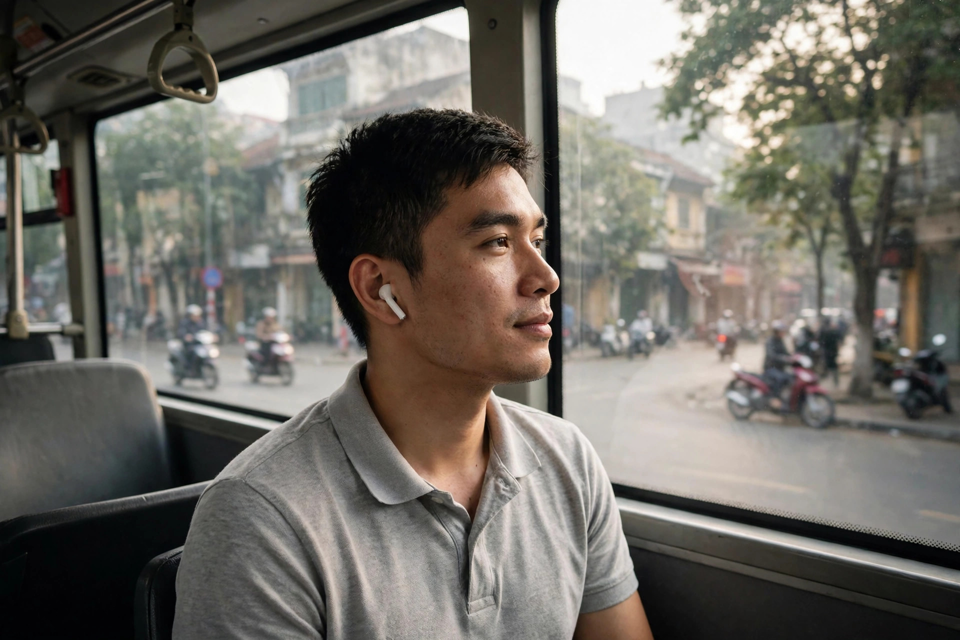 Người đi làm đeo tai nghe bluetooth trên xe buýt