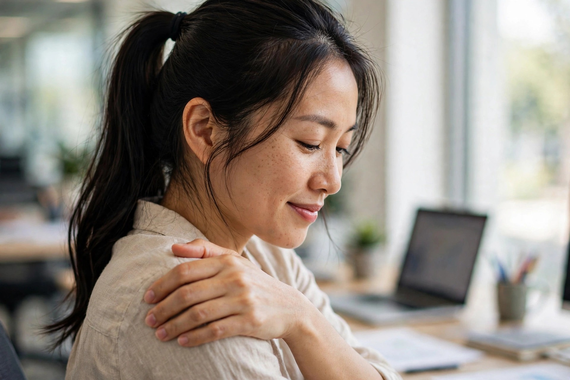 Nhân viên văn phòng xoa bóp vai tại bàn làm việc